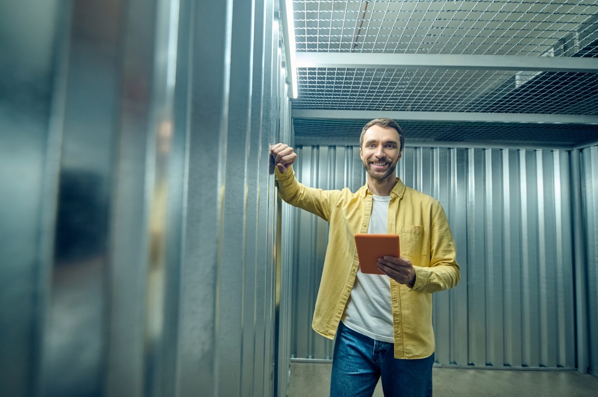 Man with tablet touching to wall in garage